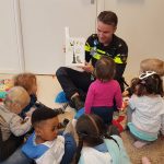 Wijkagent Piet Zwagerman leest voor op een kindcentrum in de Dapperbuurt Amsterdam