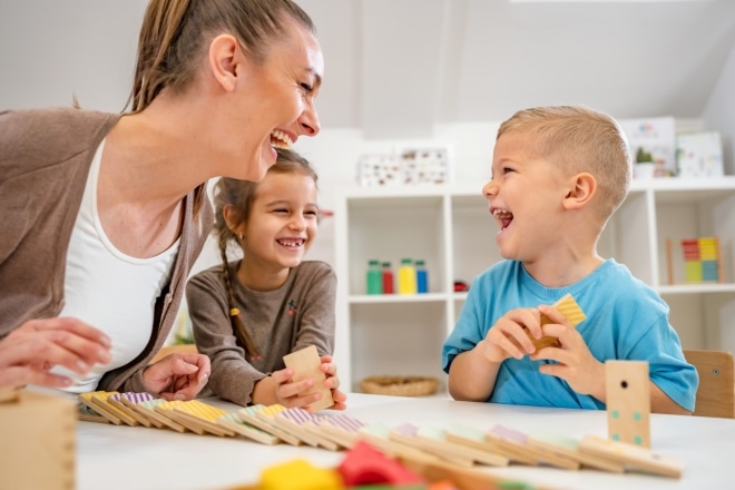 Vrolijke pedagogisch medewerker met kind