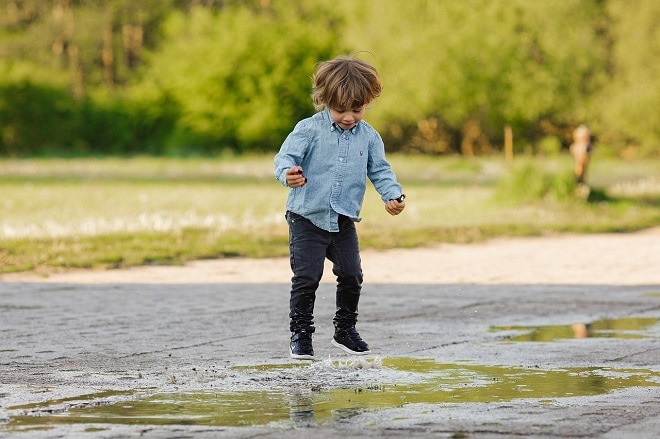 jongen springen plassen regen