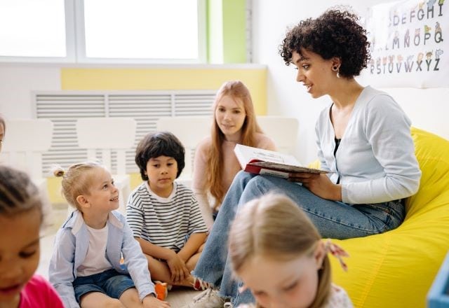 Pedagogisch medewerker leest kinderen voor