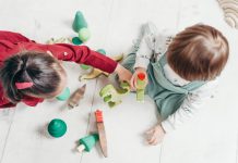 Twee kinderen spelen samen met houten speelgoed.