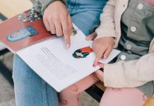 Pedagogisch medewerker leest meisje voor uit boek.