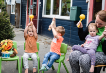 Kinderen vieren buiten een feestje op de kinderopvang.