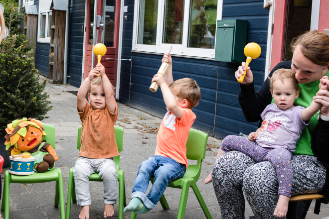 Kinderen vieren buiten een feestje op de kinderopvang.