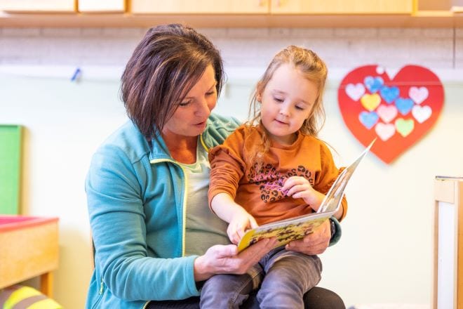 Pedagogisch medewerker Belinda leest een kind voor.