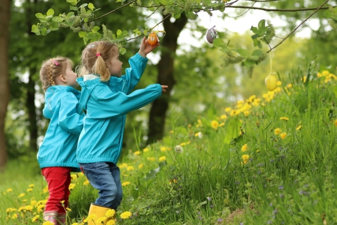 Twee meisjes staan tussen lente bloemen rond pasen