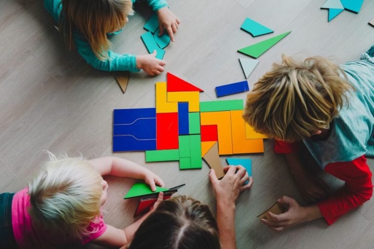Kinderen leggen een moeilijke puzzel met kleurtjes.