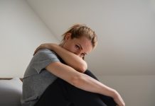 Vrouw maakt zich zorgen, heeft arm voor gezicht.