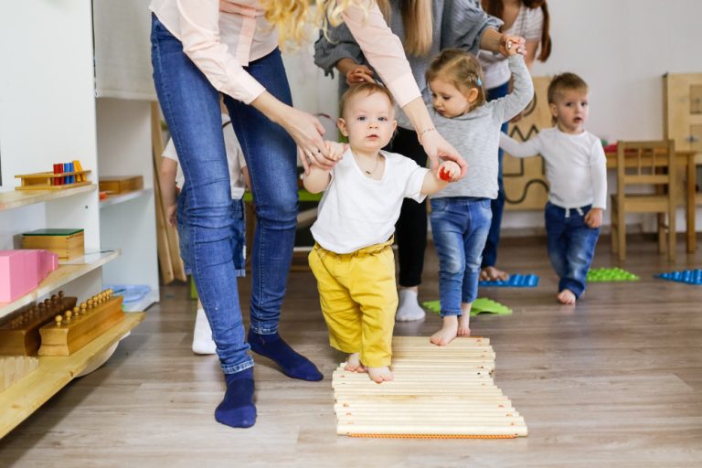 Kids with moms walks on sensory path in montessori