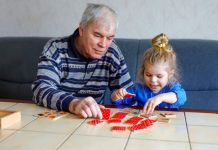 Oudere en peuter doen samen een puzzel