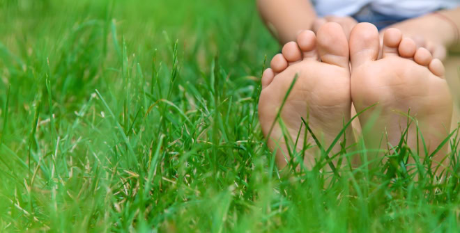 Children's feet on the green grass in the park. Selective focus. nature.
