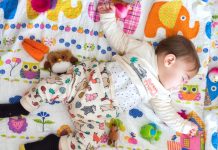 baby slapend op een gekleurde mat