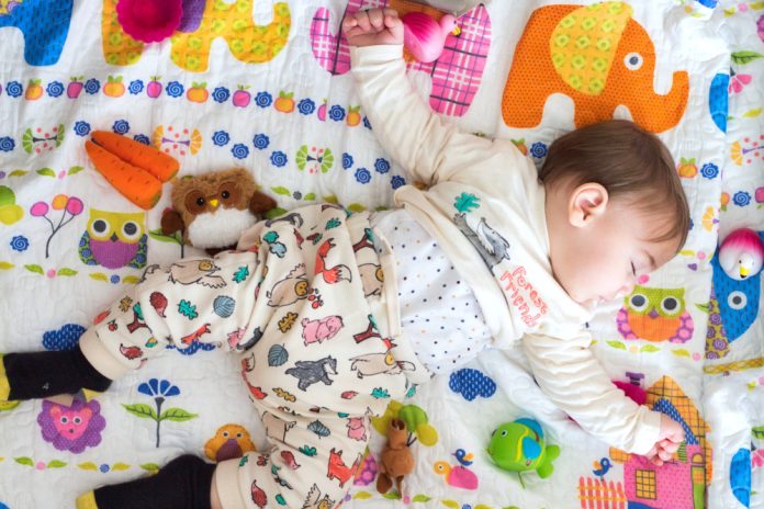 baby slapend op een gekleurde mat