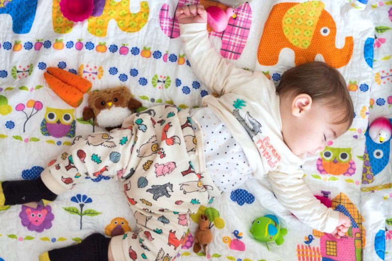 baby slapend op een gekleurde mat