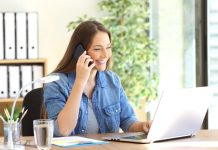 Vrouw zit lachend achter laptop te bellen