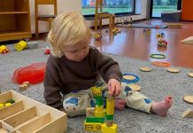 kind speelt op de grond met blokken