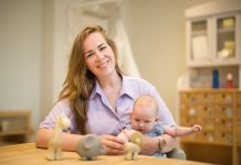 Mirjan Hendriks-Wassens aan tafel met baby op schoot