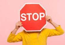 ‘Stop is genoeg!’ Zo leer je kinderen grenzen aan te geven Kind met een stopbord voor het gezicht