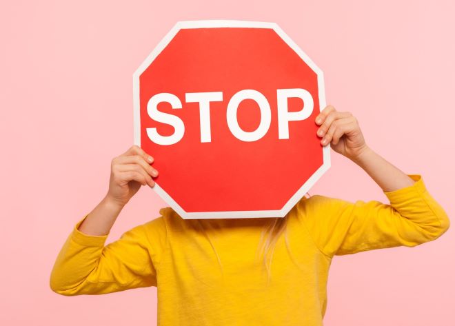 Kind met een stopbord voor het gezicht