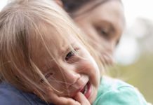 Peuter, meisje, huilend tegen haar mama aan