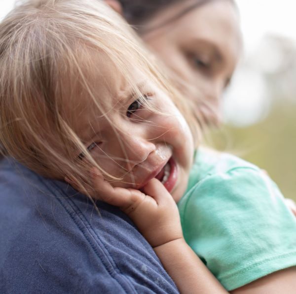 Peuter, meisje, huilend tegen haar mama aan