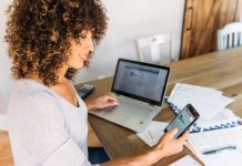 Vrouw achter laptop en telefoon