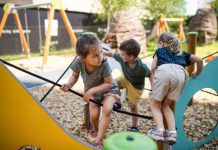 Group of small nursery school children playing outdoors on playground
