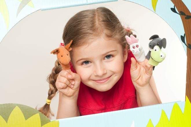 Meisje, kleuter met vingerpoppetjes in de vorm van dieren.