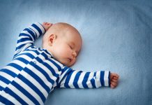 little boy sleeping on soft blue blanket
