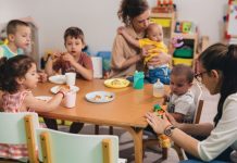 Pedagogisch professionals aan tafel met een aantal kinderen