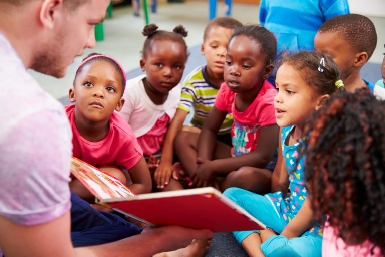 Faalangst op de werkvloer: pp’ers die niet durven voorlezen Volunteer teacher reading to a class of preschool kids *** Local Caption *** © Monkey Business / stock.adobe.com
