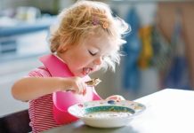 Het eetmoment Tijd om het anders aan te pakken? Peuter met een plastic slab om aan het eten