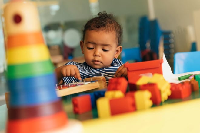 Onderzoek: ondanks campagnes en subsidies loopt het personeelstekort op Happy baby playing with toy blocks in the kindergarten.