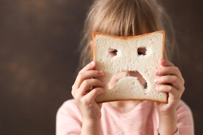 AdobeStock_492864978-2 diet celiac gluten free sad bread in the hands of a child