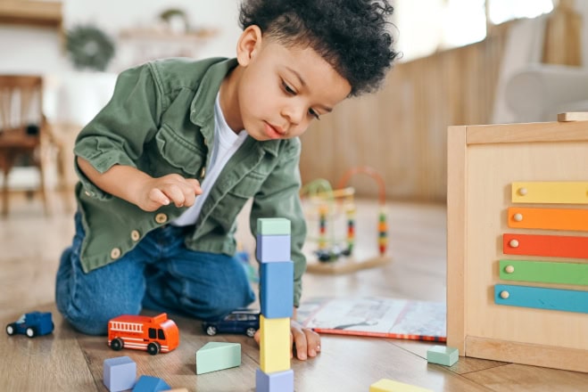 AdobeStock_584618590kl Jongen van peuterleeftijd op de peuteropvang, speelt met blokken.