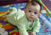 Kids Actief Baby ligt op z'n buik op een kleedje