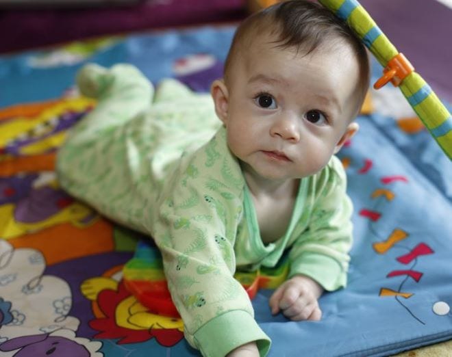 Kids Actief Geluid onder het doek Baby ligt op z'n buik op een kleedje