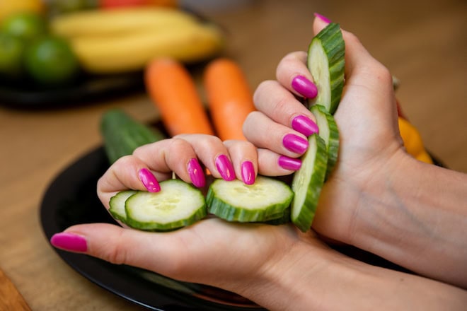 Close-up of woman's hands holding cucumber slices nieuwe-hygiënecode-kinderopvang