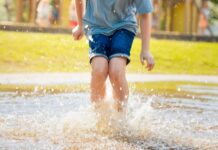 Jongen springt in water in speeltuin