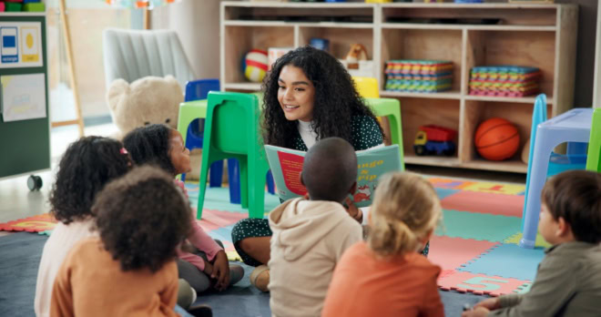 AdobeStock_1452081580-2 Lezen, onderwijs en een leerkracht met kinderen in de klas om te leren, met boeken en leerlingen. Groei, kleuterschool en onderwijsinstelling met een vrouw en kinderen op school, voor jeugd, voorleestijd en de ontwikkeling van het kind.