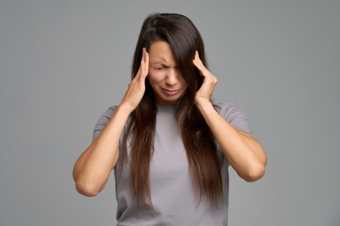 Moe-door-slechte-akoestiek-Dit-moet-prioriteit-krijgen gestresste vrouw houdt haar ogen dicht en duwt haar handen tegen haar oren