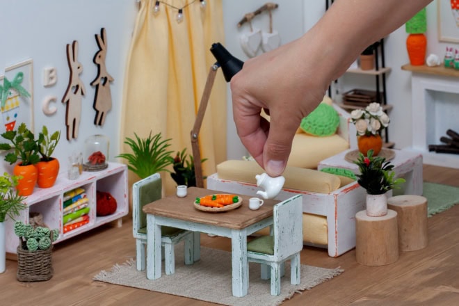 Pp’ers die geen verkleinwoordjes gebruiken: dit zit erachter Een vrolijke, lichte kamer in een poppenhuis, ingericht met miniatuurmeubeltjes. Een persoon schenkt voor de lol thee uit een theepot