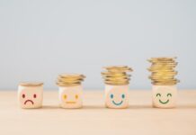 Gemeenten mogen straks bepalen welke ouders extra steun krijgen voor kinderopvang Emotioneel gezicht op een stapel munten, geld besparen, sparen, welvaart, winst, geld voor een zorgbudget of verzekeringsconcept.