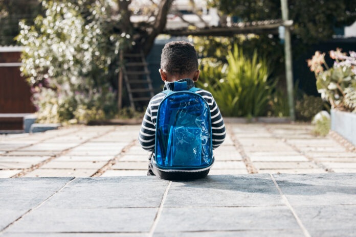 Shot of a little boy sitting outside with his backpack jongen met rugzak