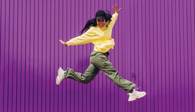 6 tips om fit te blijven werken fitte vrouw die springt en blij is