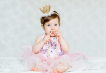Kinderen die je bijblijven: ‘Dit kán gewoon niet!’ Charming blue-eyed baby girl in a dress and a crown wiht pearls