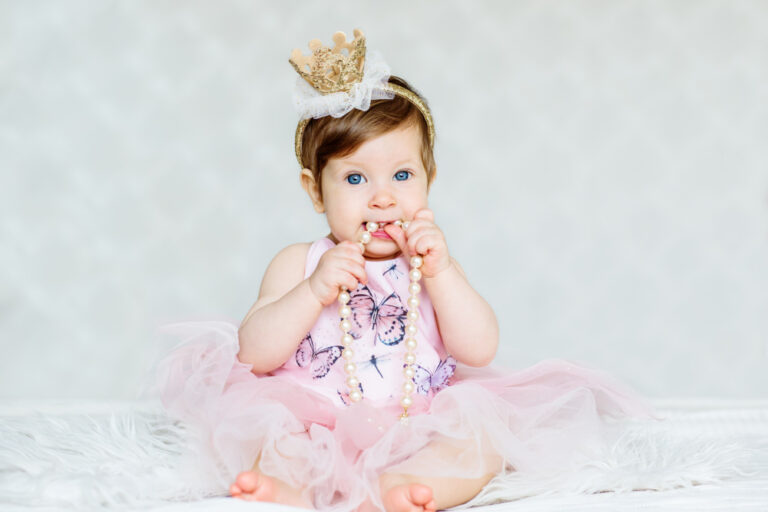 Kinderen die je bijblijven: ‘Dit kán gewoon niet!’ Charming blue-eyed baby girl in a dress and a crown wiht pearls