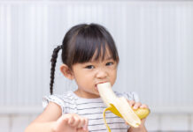 Het bananen-effect: waarom een kind op de opvang net iets meer kan en doet dan thuis Meisje met banaan